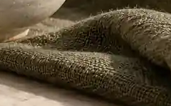 The same linen crop from WebP quality 30, where fine threads merge into smoother areas.